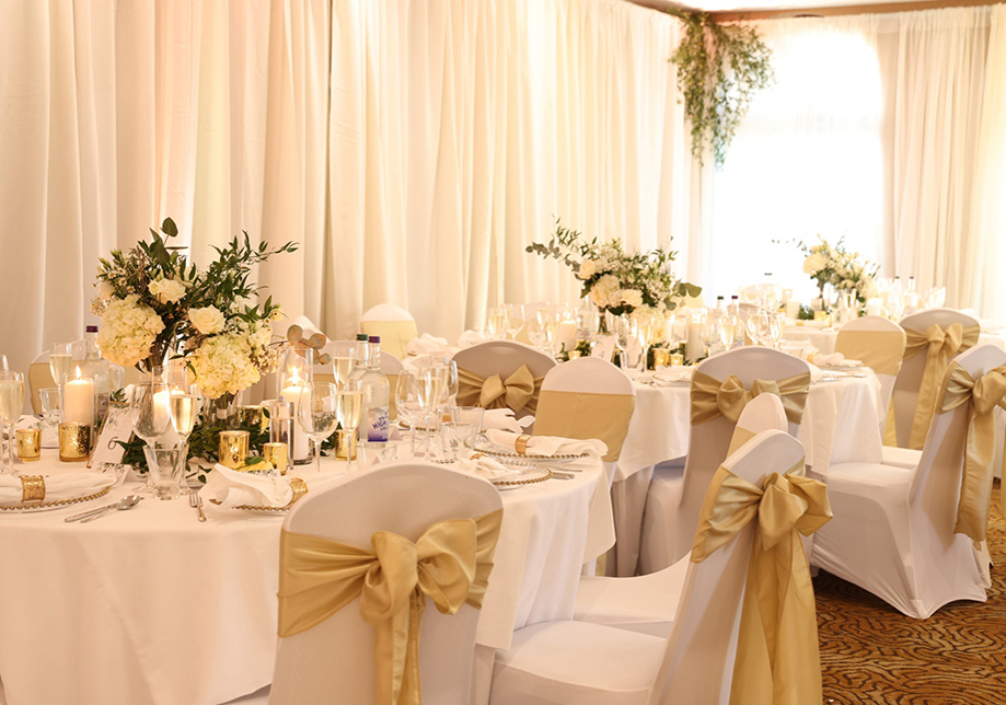 Wedding meal set up with cream accents and floral arrangements on tables